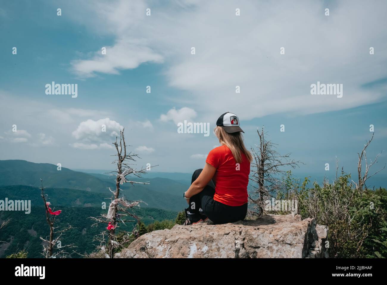 A girl on top of Falaza mountain looks at a beautiful mountain valley. Travel and tourism. Hiking Stock Photo