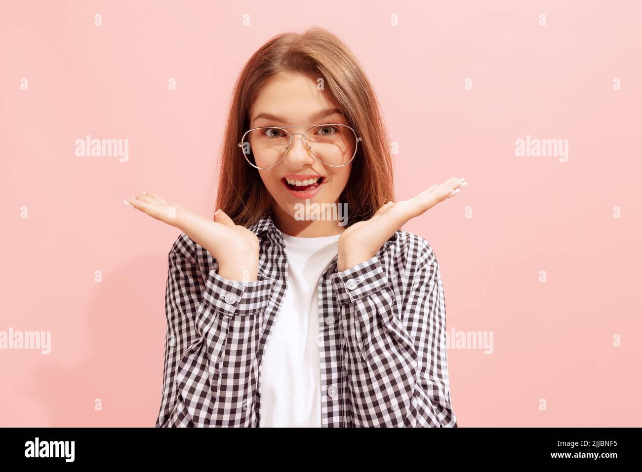 Portrait of young girl posing isolated over pink studio background ...