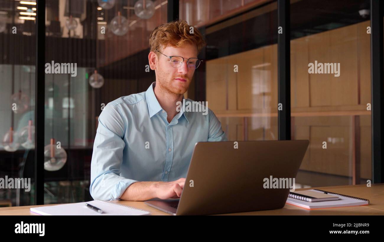 Young businessman working on laptop and studying using computer at office. Stock Photo