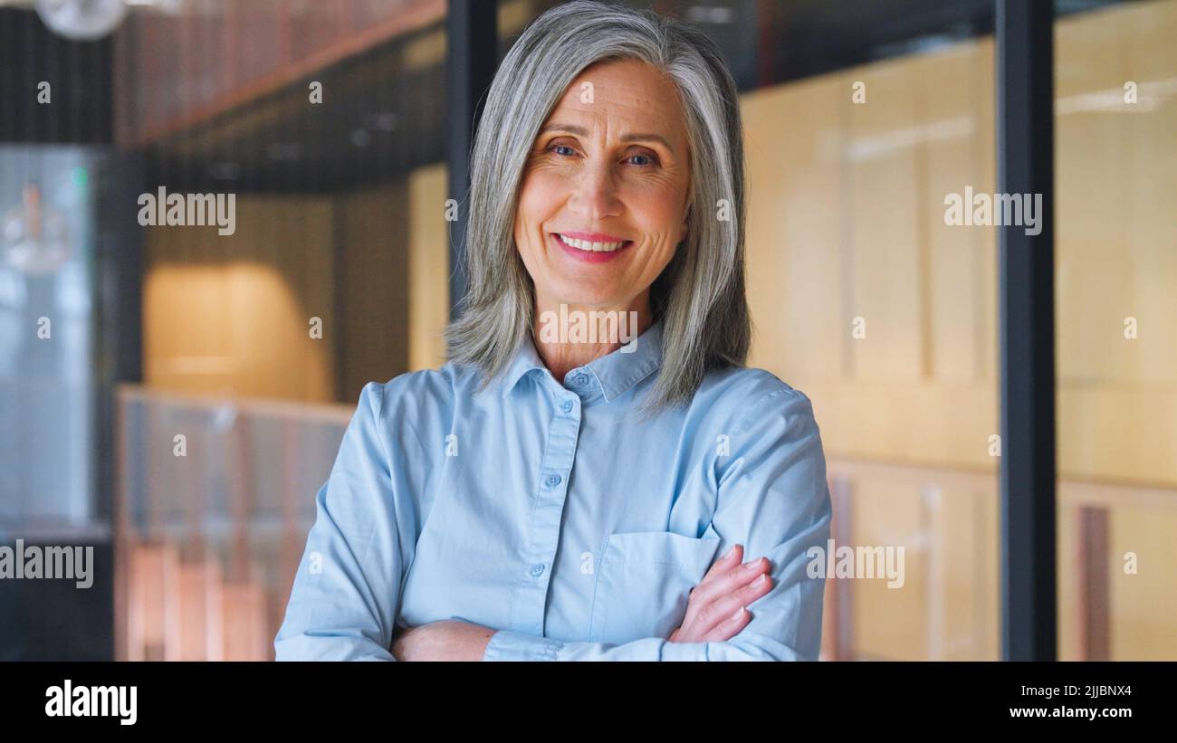 Portrait of smiling confident 60-s gray-haired mature woman. Stock Photo