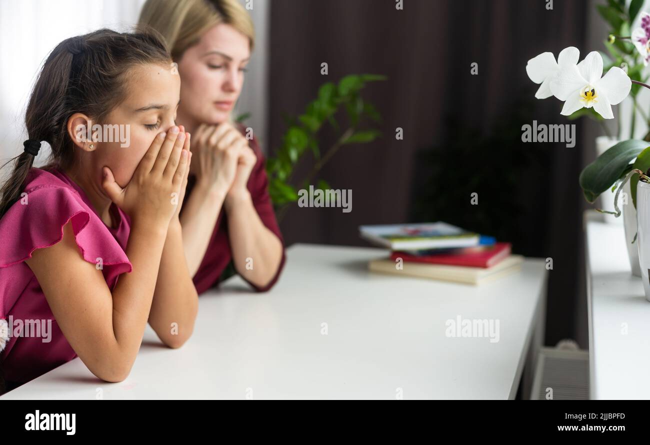 Mother teaching her daughter to praying. Stock Photo