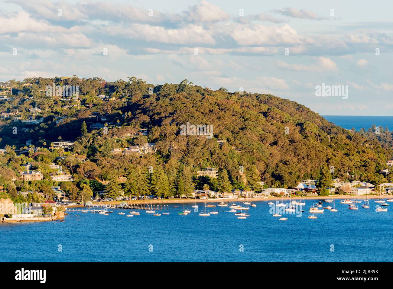 Boats moored on the Pittwater side of Palm Beach between Observation Point (L) and Sand Point (R) in Sydney Australia in the late afternoon winter sun Stock Photo