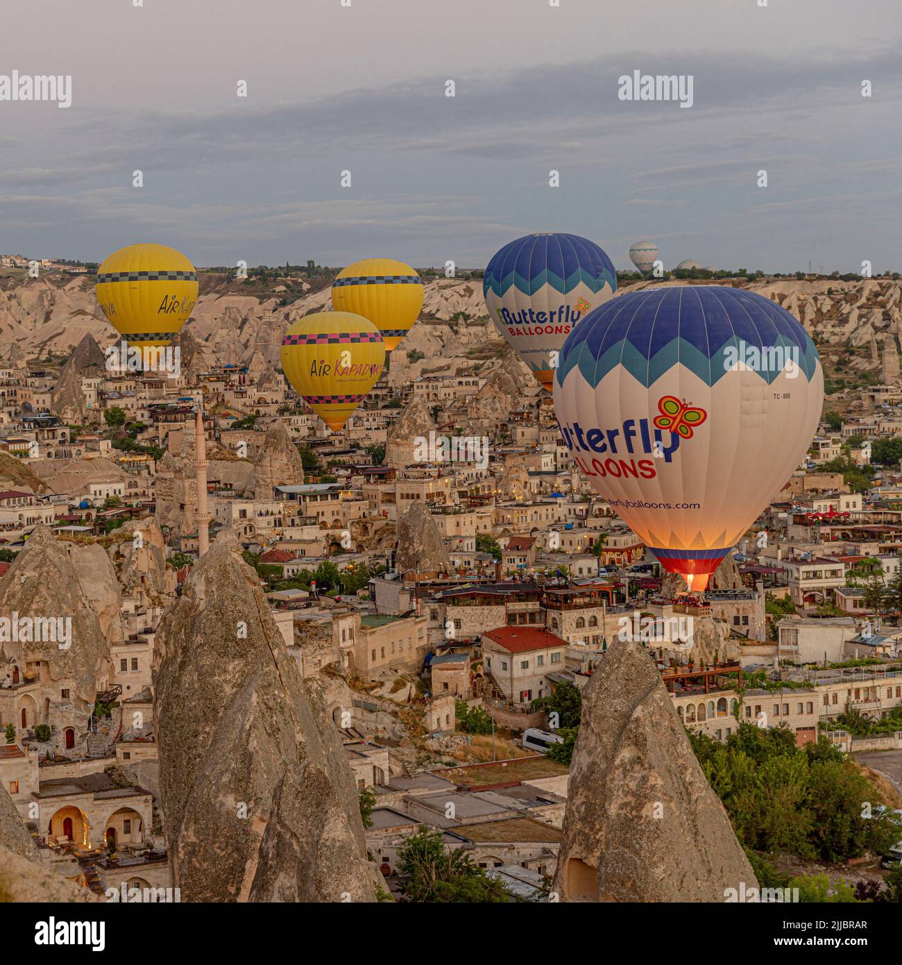 GOREME/TURKEY - June 29, 2022: hot air balloons fly low over the city of goreme at sunrise Stock Photo
