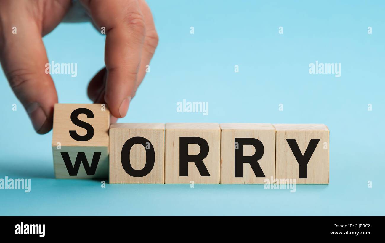 Sorry to worry. Hand turns a cube and changes the word worry to sorry. Business concept, copy space. Stock Photo