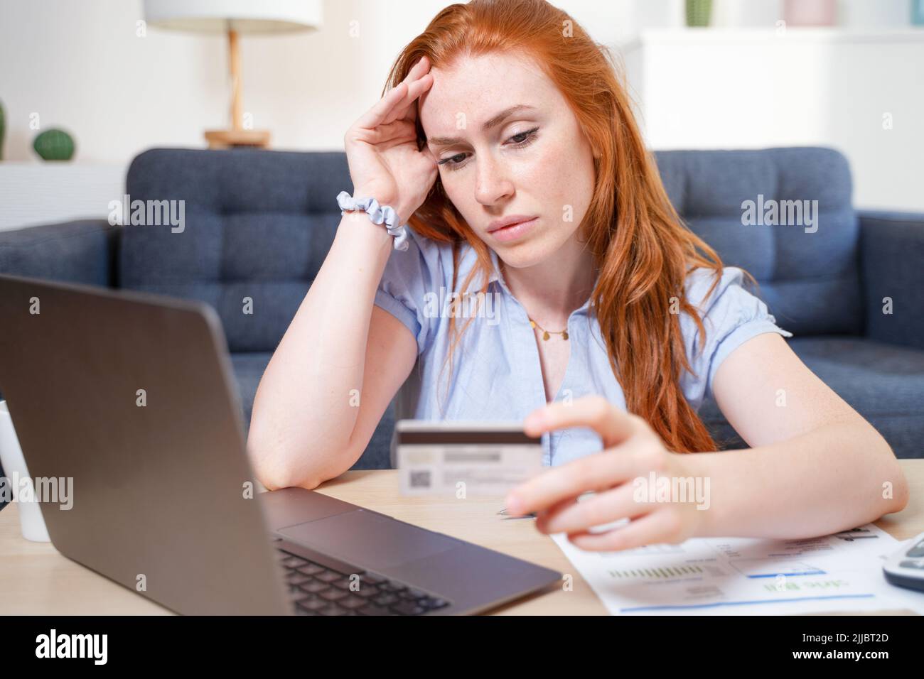 Sad woman checking bank account still in the red Stock Photo