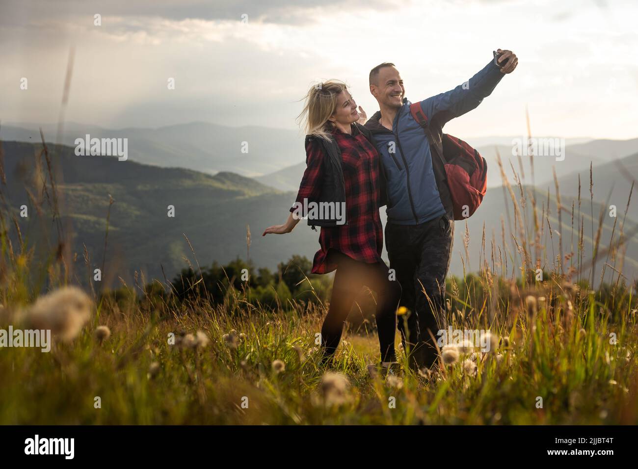 Two hikers relax on top of a mountain with great view Stock Photo - Alamy