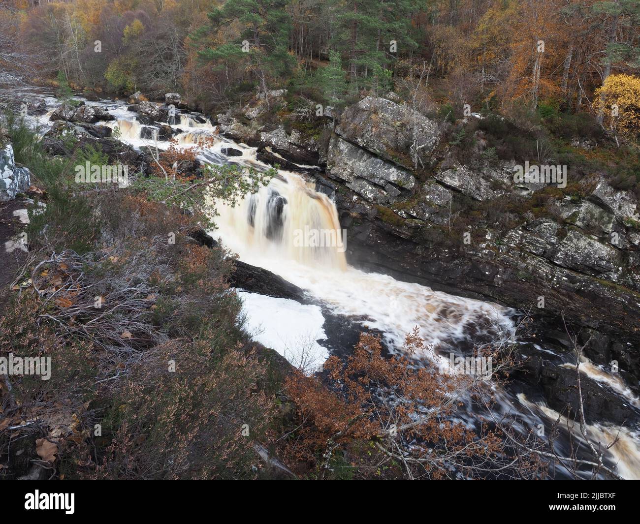 A late autumn day at Rogie Falls, on the Black Water river, near Strathpeffer. Trees in autumnal colours, & rocks surrounding the cascades. Stock Photo