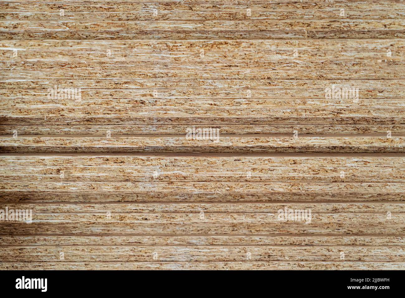 Stack of OSB plywood sheets from compressed sawdust texture. Stock Photo