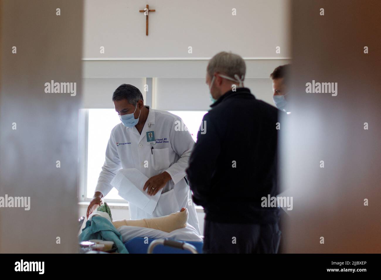 Dr. Vishal Bansal, head of the trauma unit at Scripps Mercy Hospital looks over a border wall fall patient as he makes morning round with resident MDs in San Diego, California, U.S. May 20, 2022.    REUTERS/ Mike Blake Stock Photo