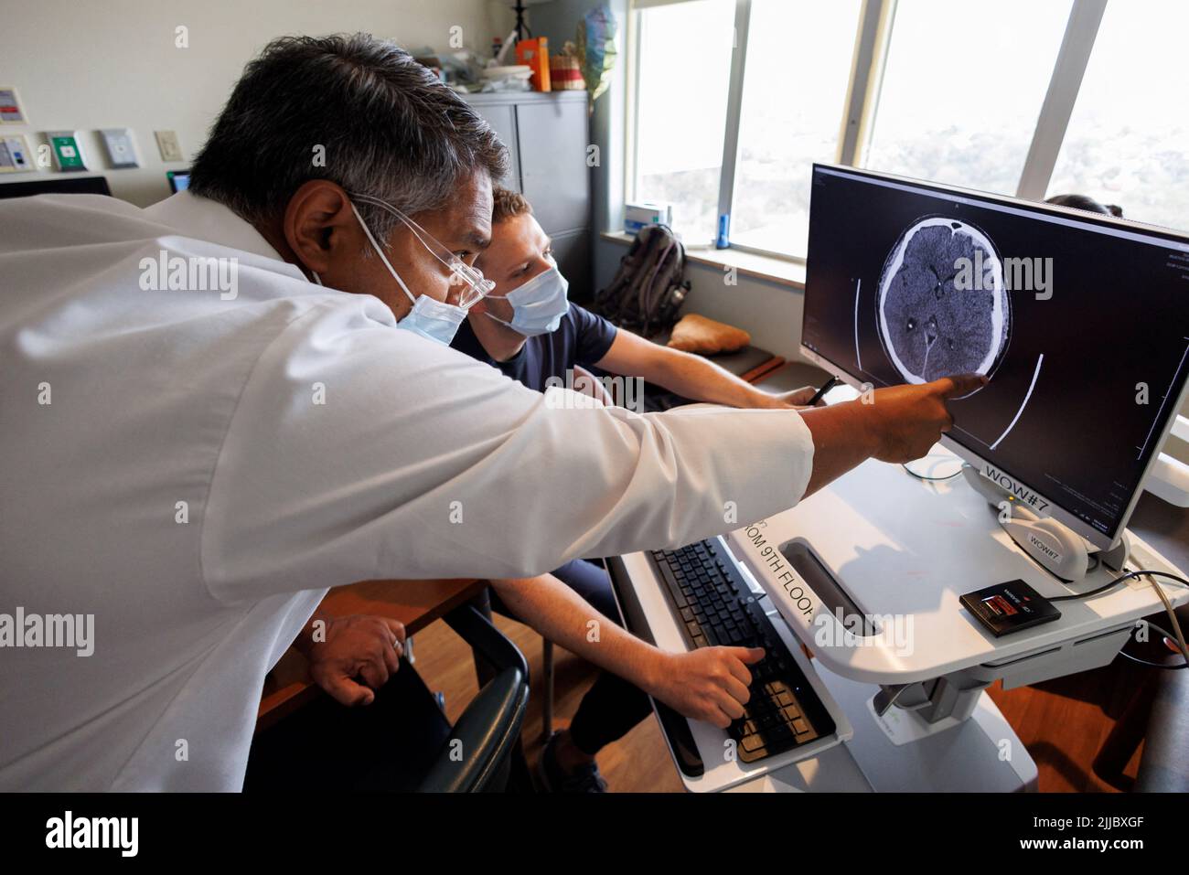 Dr. Vishal Bansal, head of the trauma unit at Scripps Mercy Hospital, looks over an MRI scan of a border wall fall patient with his resident MDs during his morning rounds in San Diego, California , U.S. May 20, 2022.  REUTERS/ Mike Blake Stock Photo