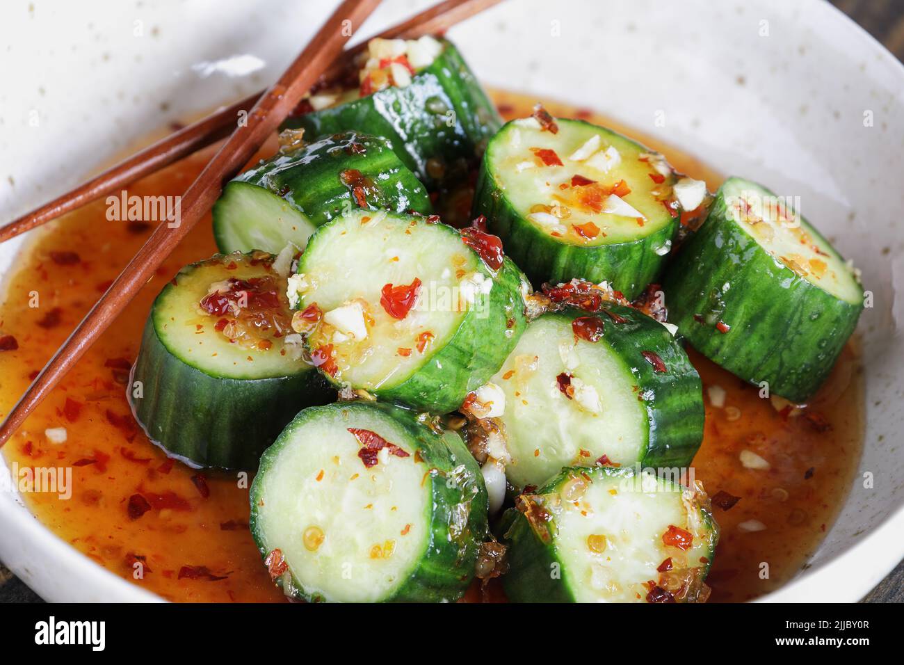 Overhead view of easy Spicy Korean Cucumber Salad, Oi Muchim, made with garlic and hot peppers. Extreme selective focus with blurred background. Stock Photo