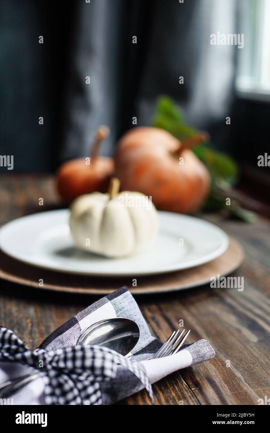 Silverware on Thanksgiving Day holiday table buffalo check napkin tied with black and white bow. Selective focus with blurred background. Stock Photo