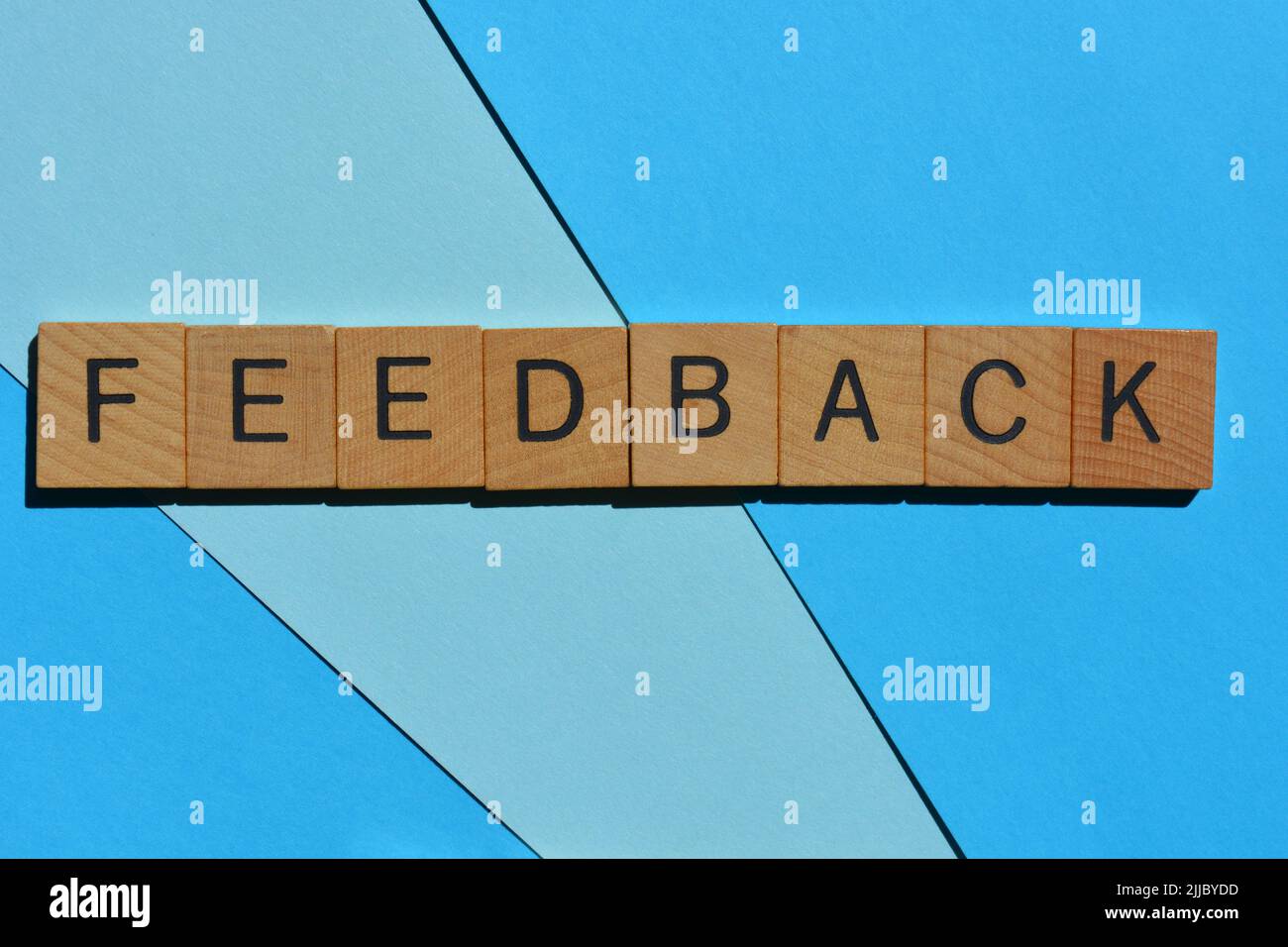 Feedback, word in wooden alphabet letters isolated on blue background Stock Photo