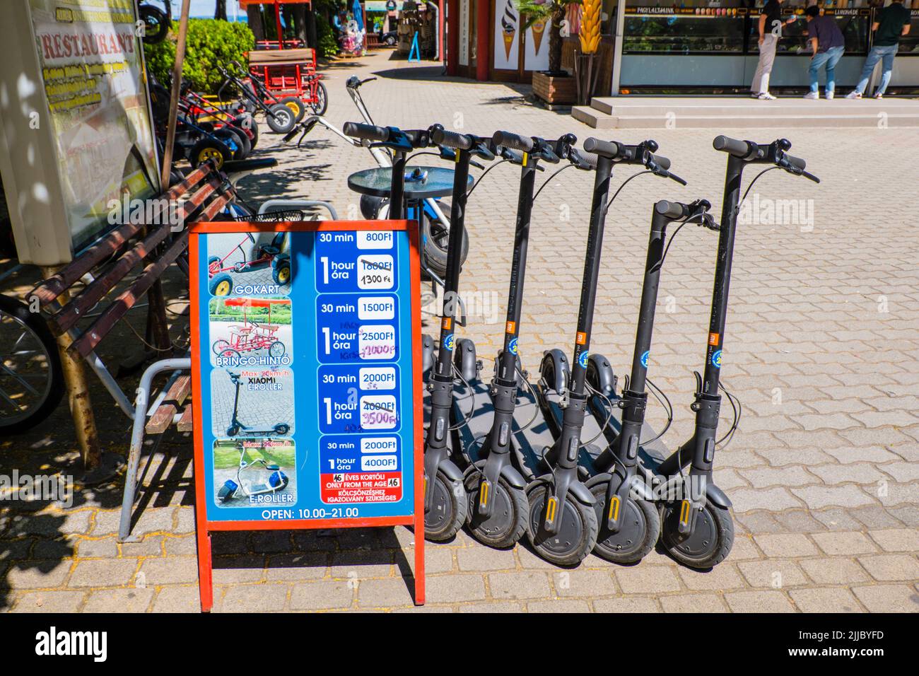 Electronic scooters and otherr modes of light transport for rent, Petőfi sétány, main pedestrian street by the beach, Siofok, Hungary Stock Photo