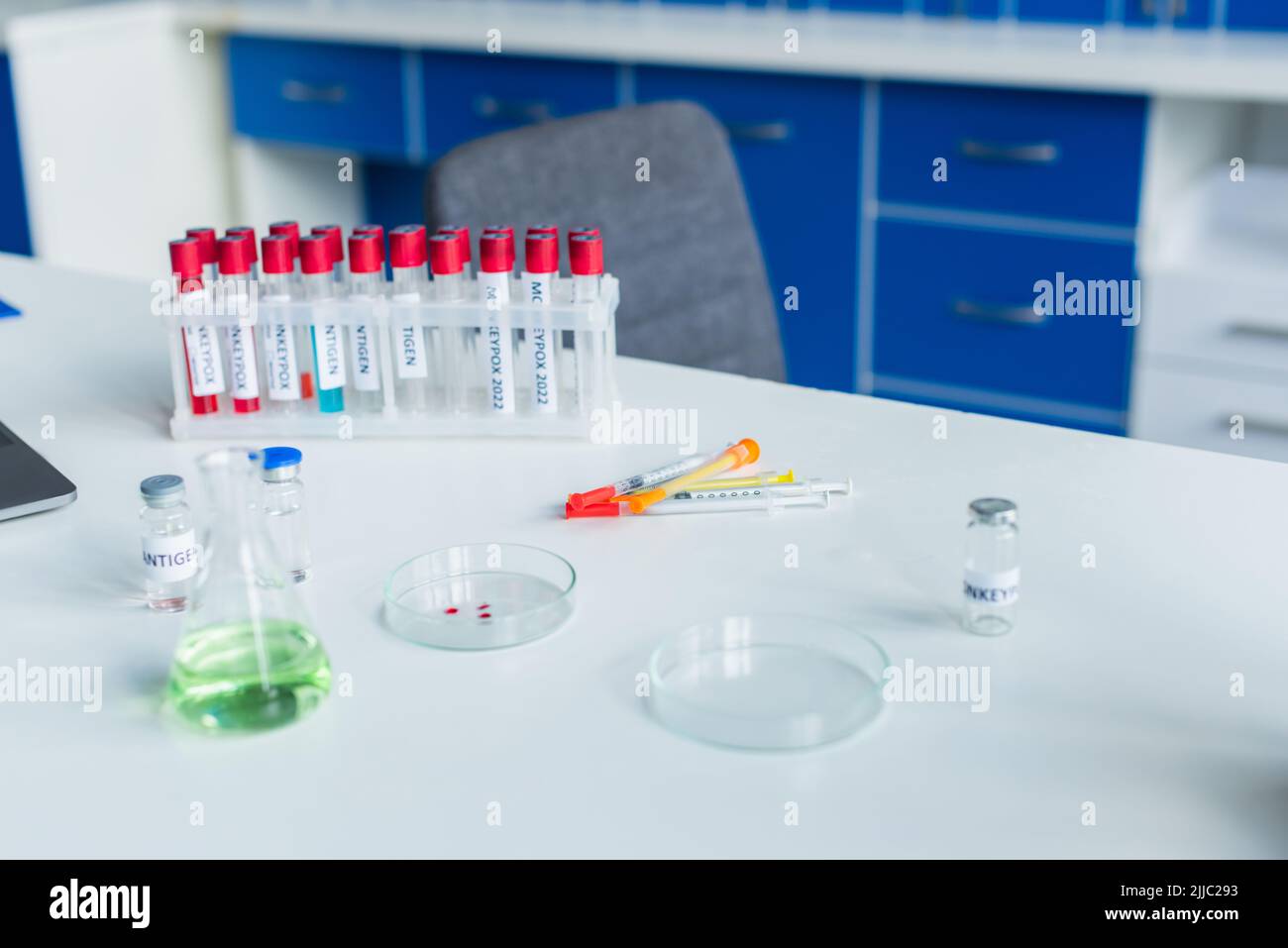 Vaccine and syringes near test tubes with monkeypox lettering in lab ...
