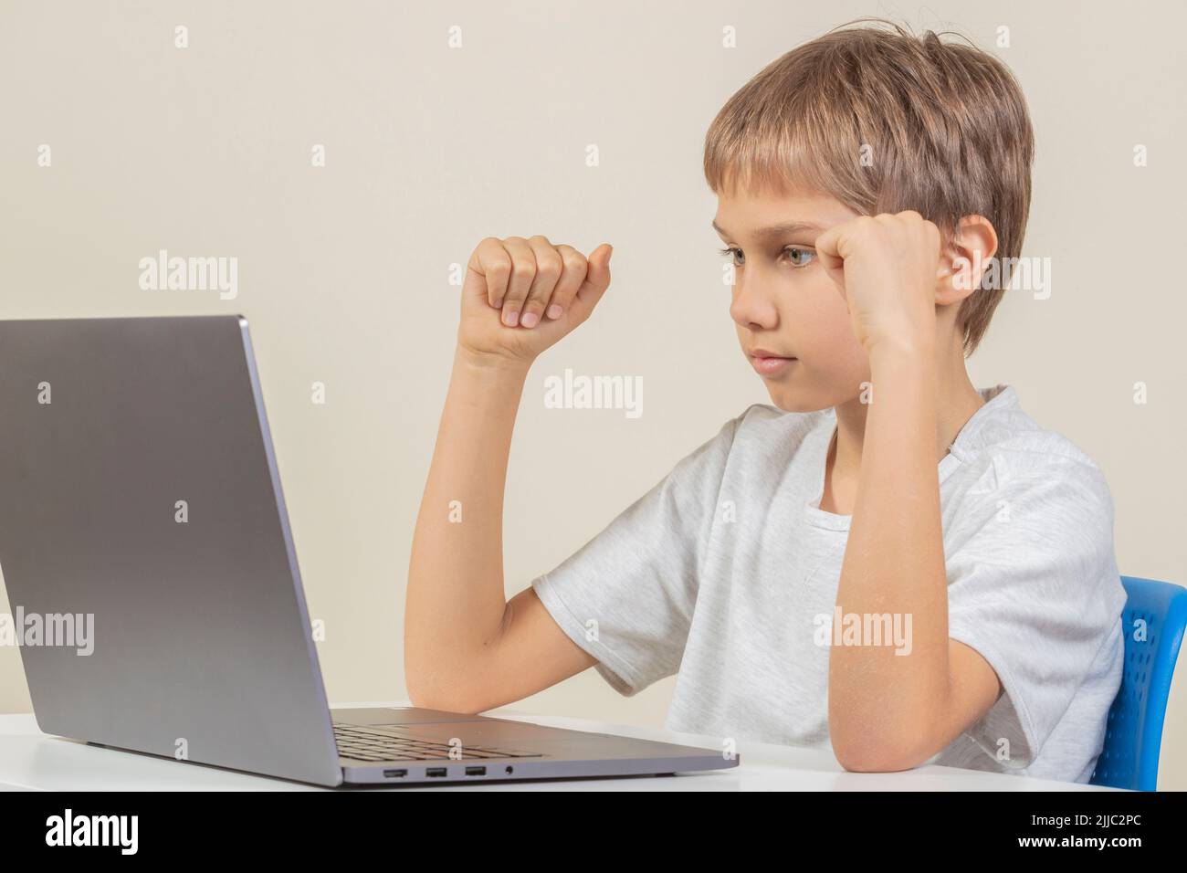 Boy looking laptop computer monitor waiting in tension for online result, hope for win, pass test, exam, online learning, education at home concept Stock Photo