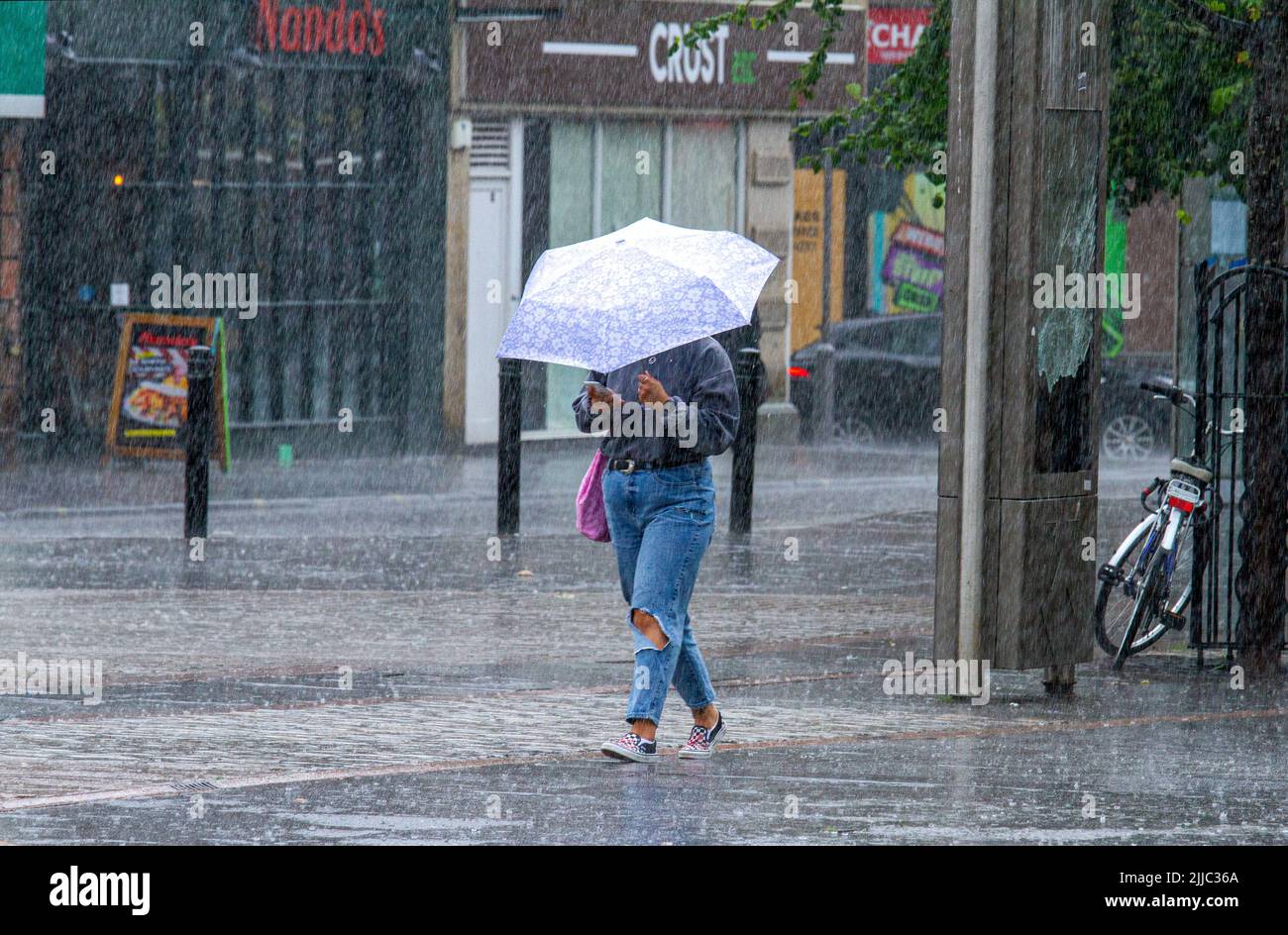 Dundee, Tayside, Scotland, UK. 25th July, 2022. UK Weather: The combination of unexpected, heavy showers and humidity caused temperatures to exceed 18°C in some areas of North East Scotland. Monday morning shoppers are caught off guard by sudden heavy downpours in Dundee city centre. Credit: Dundee Photographics/Alamy Live News Stock Photo