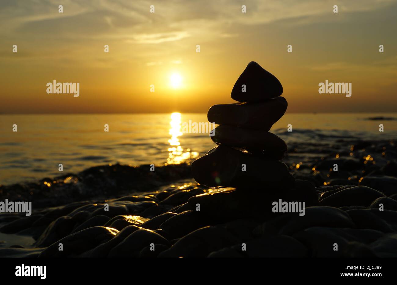 Spiritual meditative summer background with silhouette of the stacking stones tower Stock Photo