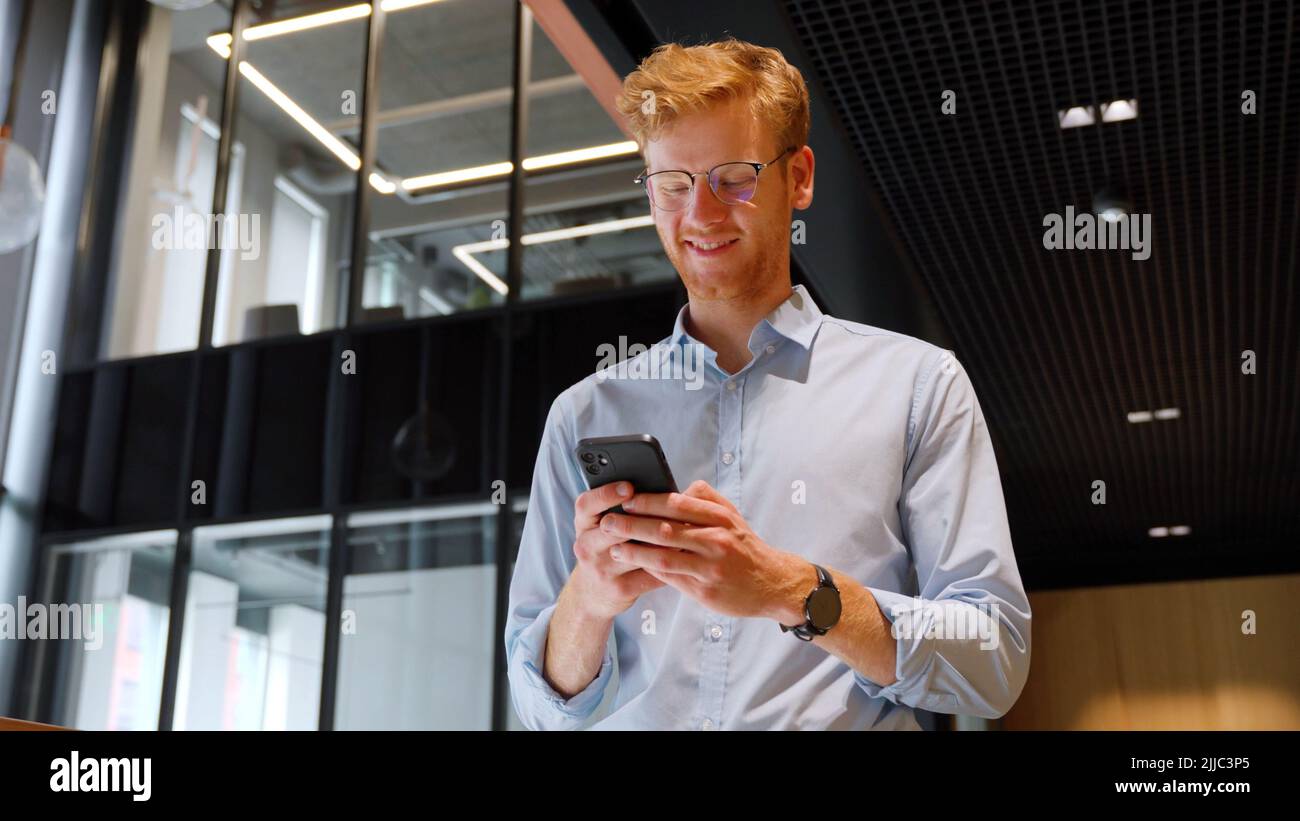 Middle aged businessman use smartphone computer apps for work in office. Stock Photo