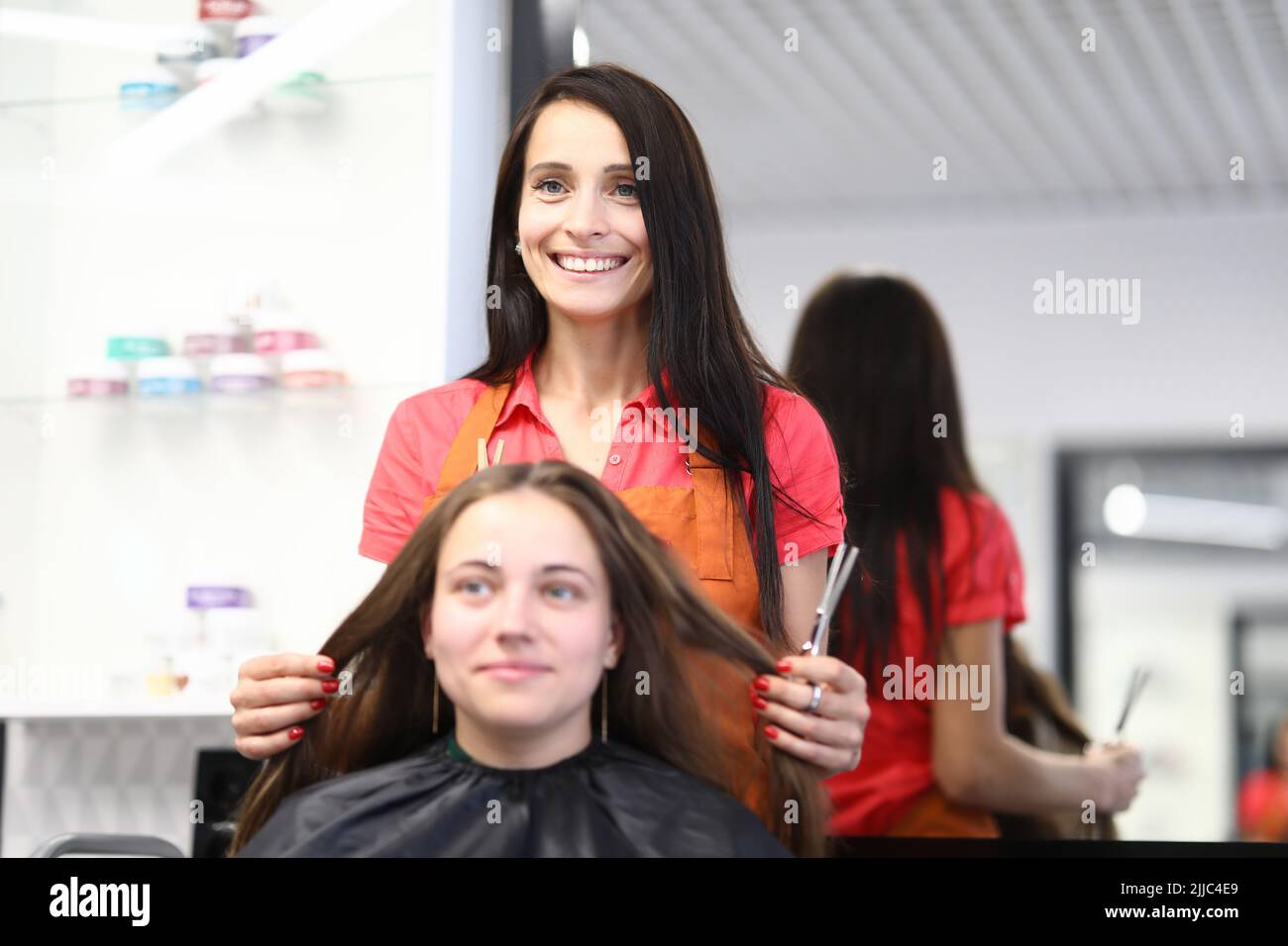 Professional hairdresser cuts female hair in salon Stock Photo