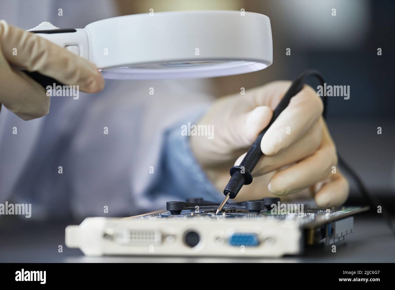 Macro shot of female engineer inspecting hardware with magnifying glass, copy space Stock Photo