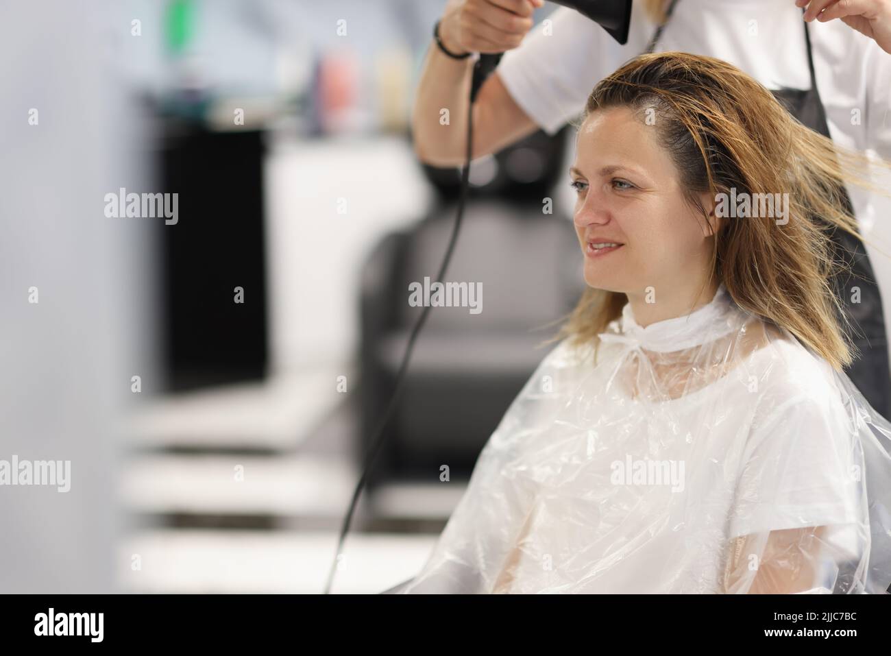 Hair styling process in beauty salon with hair dryer Stock Photo