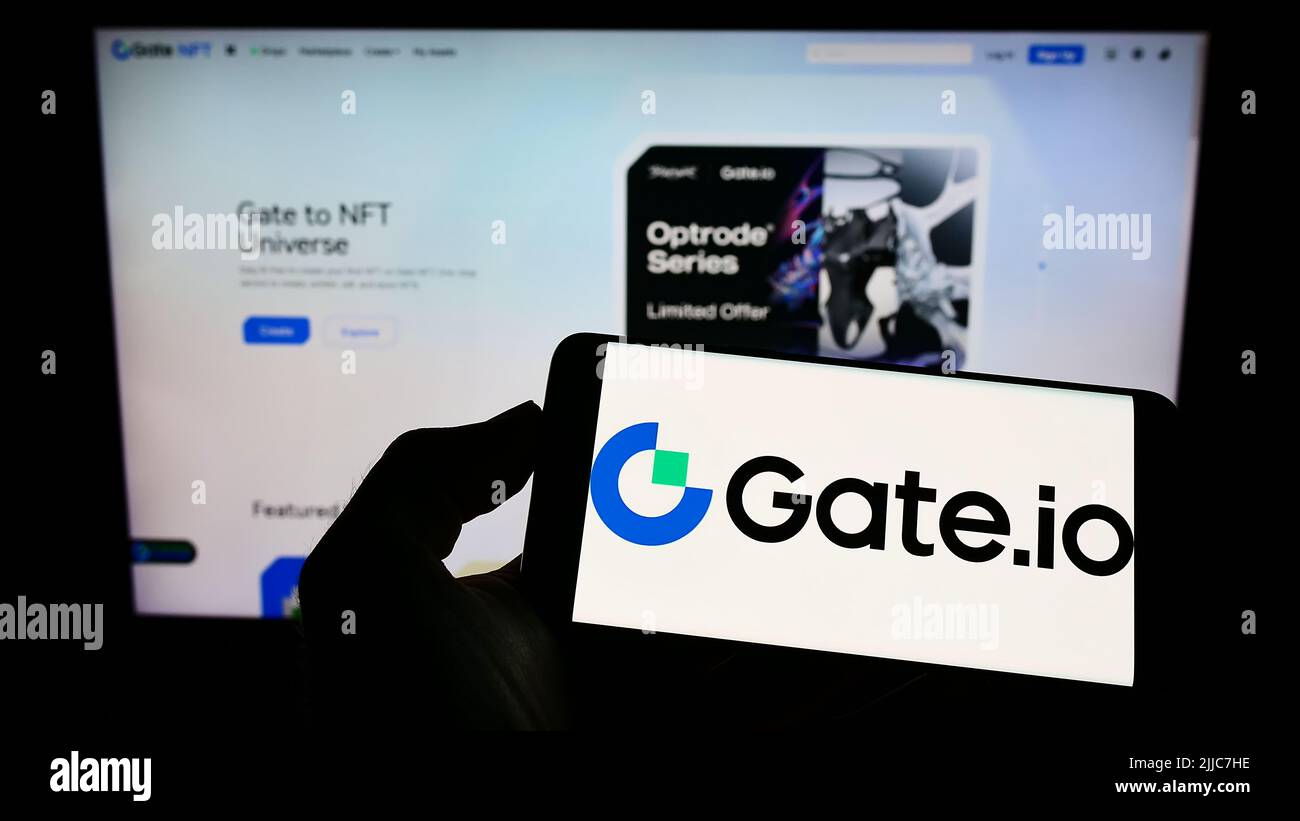 Gate.com Person holding cellphone with logo of crypto exchange company Gate ...
