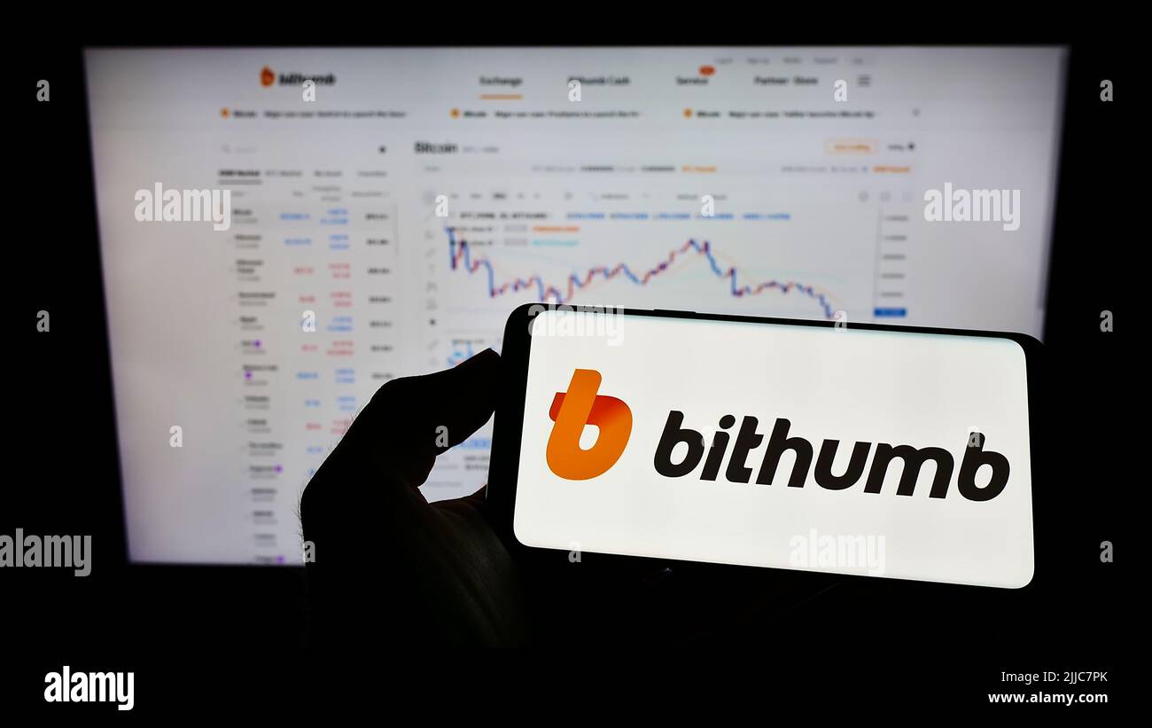Person holding mobile phone with logo of South Korean cryptocurrency ...