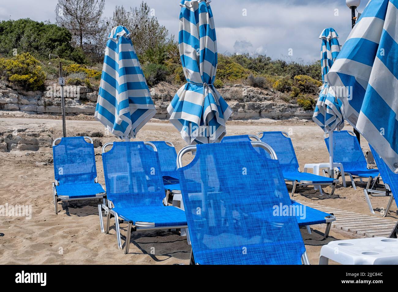 Greek beach with sunbeds and parasols Stock Photo