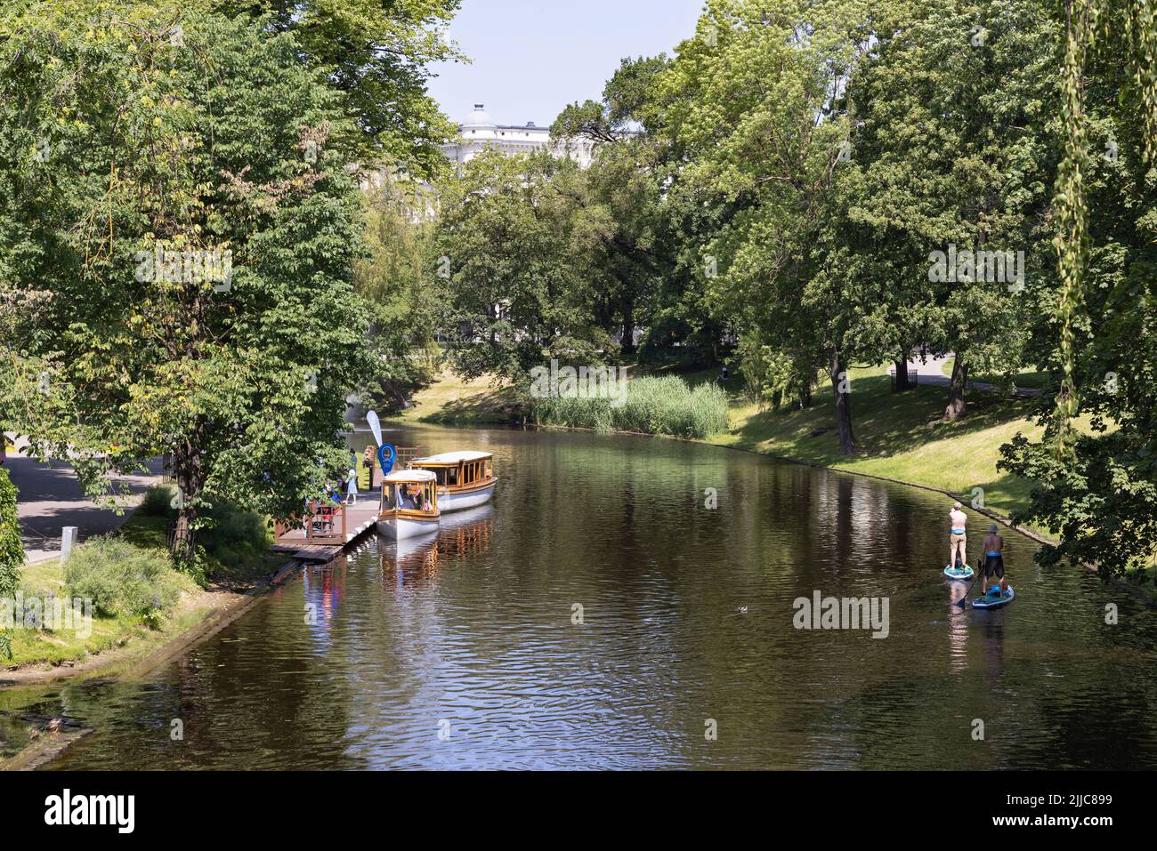 Latvia summer; Canal boat on the Riga City Canal giving tourists on holiday a sightseeing tour, Riga old town, Riga Latvia Europe; Latvia Travel. Stock Photo