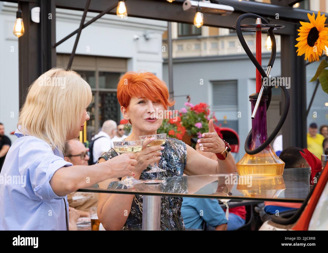 Wine friends; Two women drinking wine on a night out in a bar, Riga, Latvia Europe. European lifestyle Stock Photo