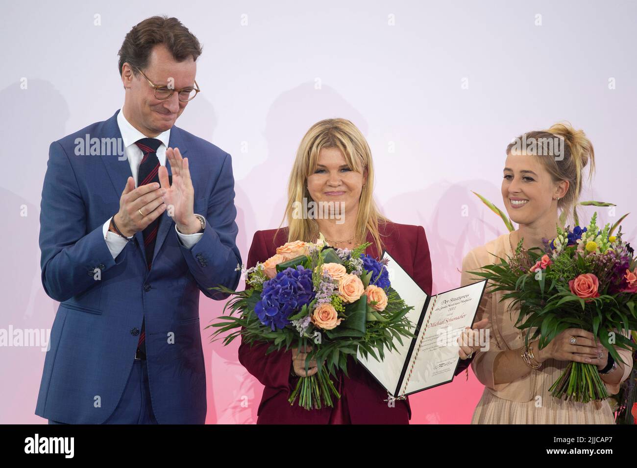 Cologne, Deutschland. 20th July, 2022. from left: Hendrik WUEST, W?st, CDU, Prime Minister of North Rhine-Westphalia, Corinna SCHUACHEr, Gina SCHUMACHER, with the state award certificate for Michael Schumacher, red carpet, Red Carpet Show, arrival, presentation of the state award North Rhine-Westphalia in Cologne on 07/20/2022 ? Credit: dpa/Alamy Live News Stock Photo