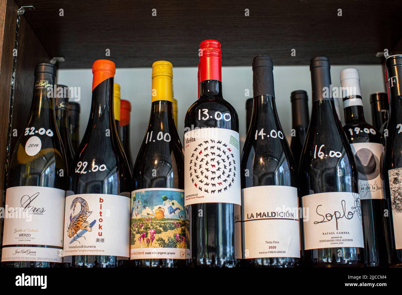 Wine bottles on wooden shelf in wine store Stock Photo