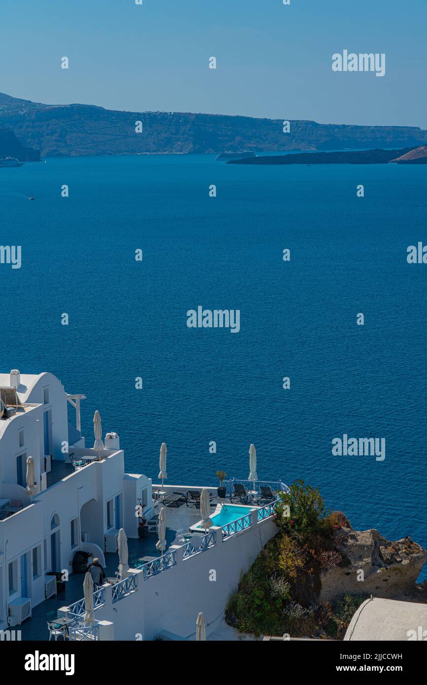 OIA, GREECE - MAY 22.2022: Building with a Pool in Oia with traditional white houses, Santorini island Stock Photo