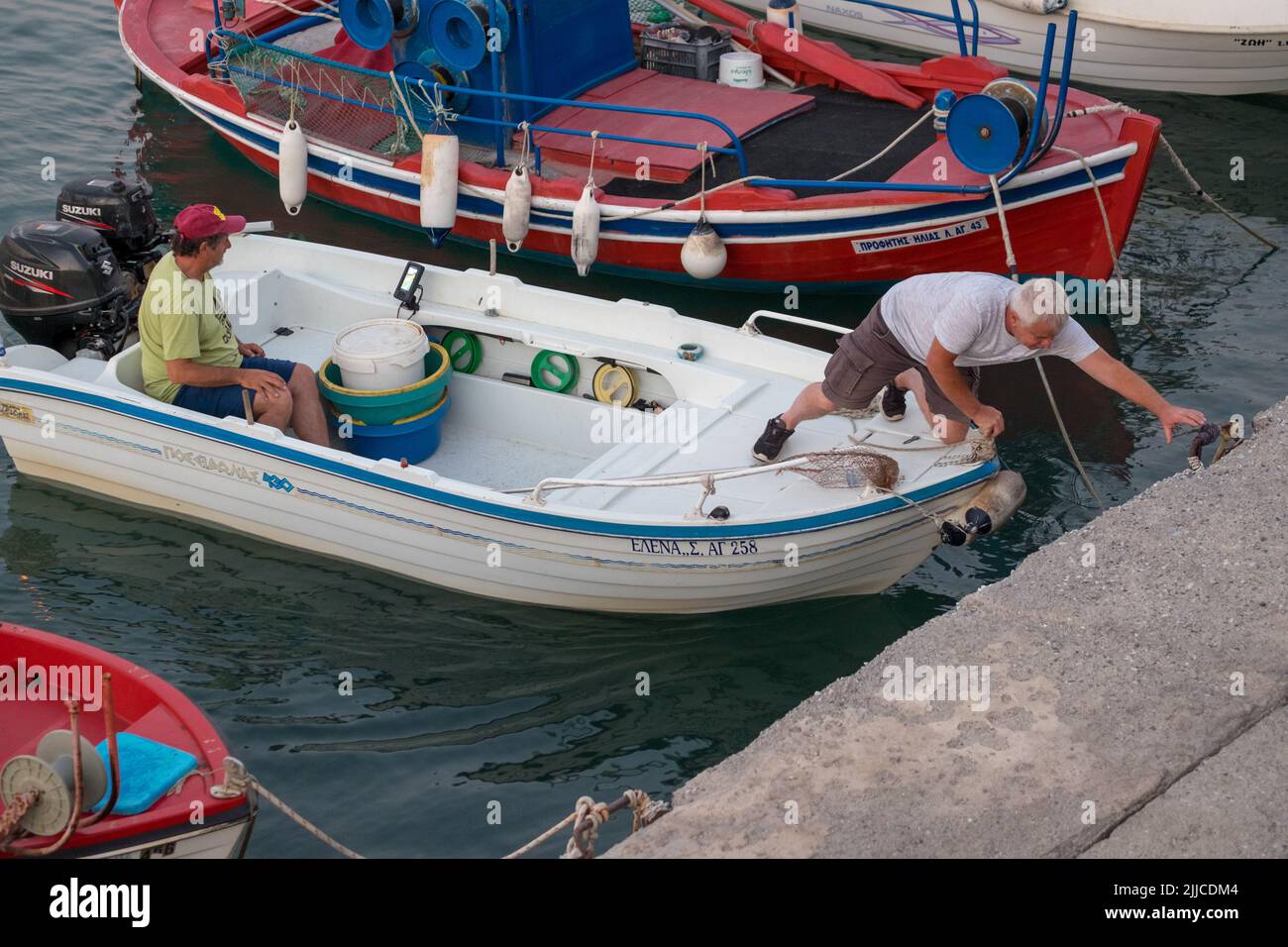 Fishermen docking their boat to the port of Agiokampos , Greece Stock Photo