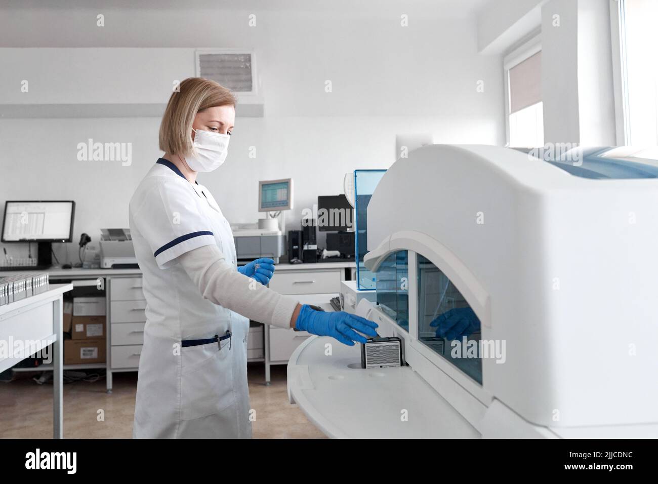 Woman replacing the ink of a printer in an hospital office Stock Photo