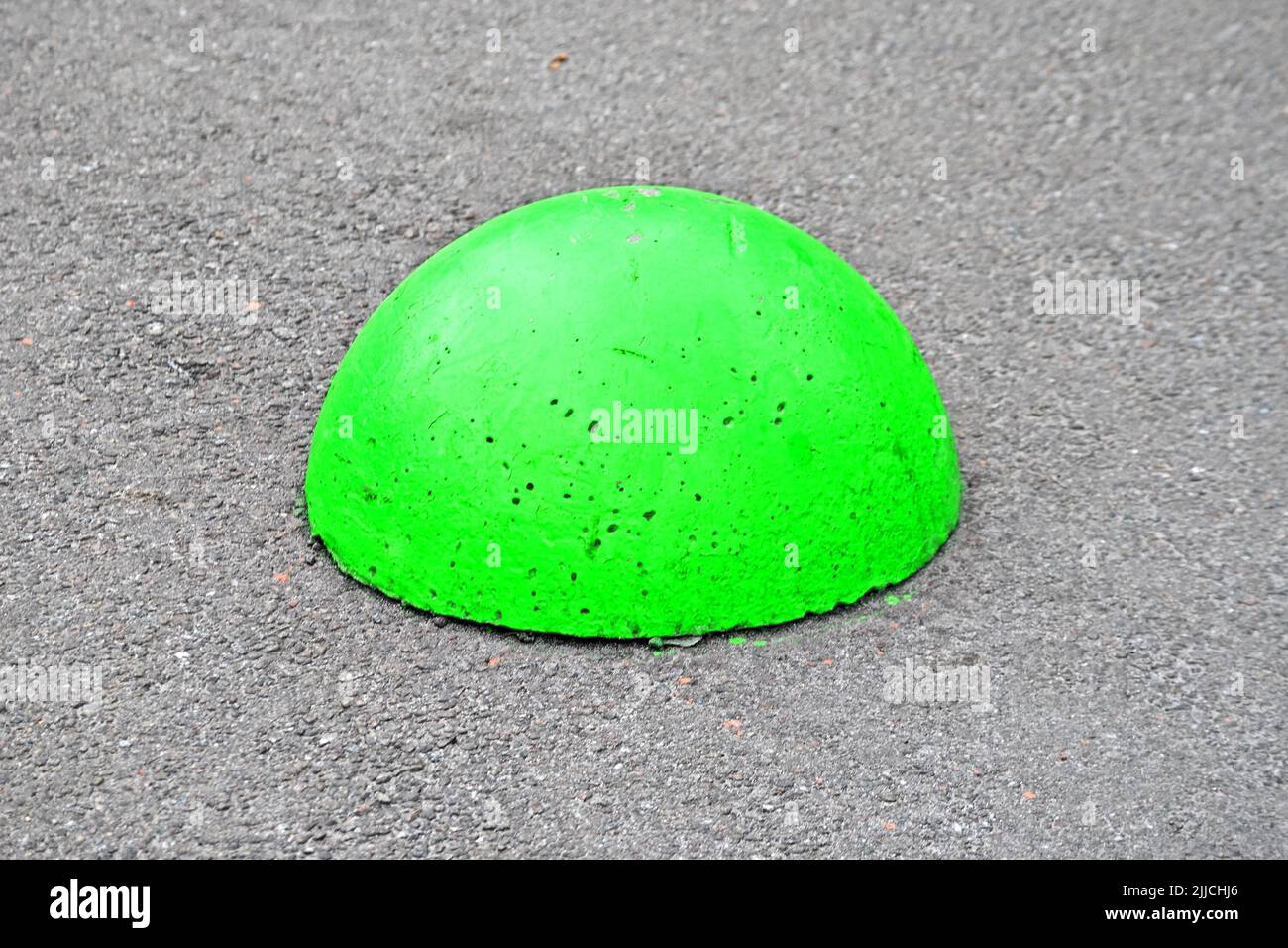 green stone sphere, pylon barrier closeup on the street, modern