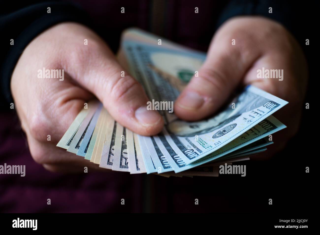 White male shows dollar bills in his hand closeup front view Stock Photo