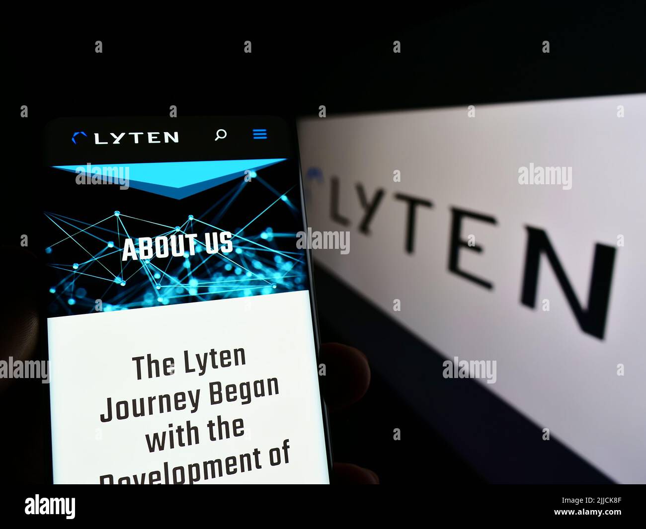 Person holding mobile phone with webpage of American battery company Lyten Inc. on screen in front of logo. Focus on center of phone display. Stock Photo