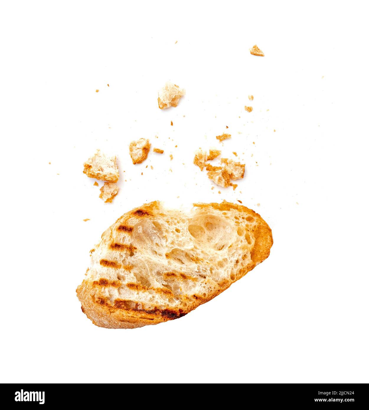 Piece of a dry white bread bruschetta or baguette with crumbs isolated on white Stock Photo