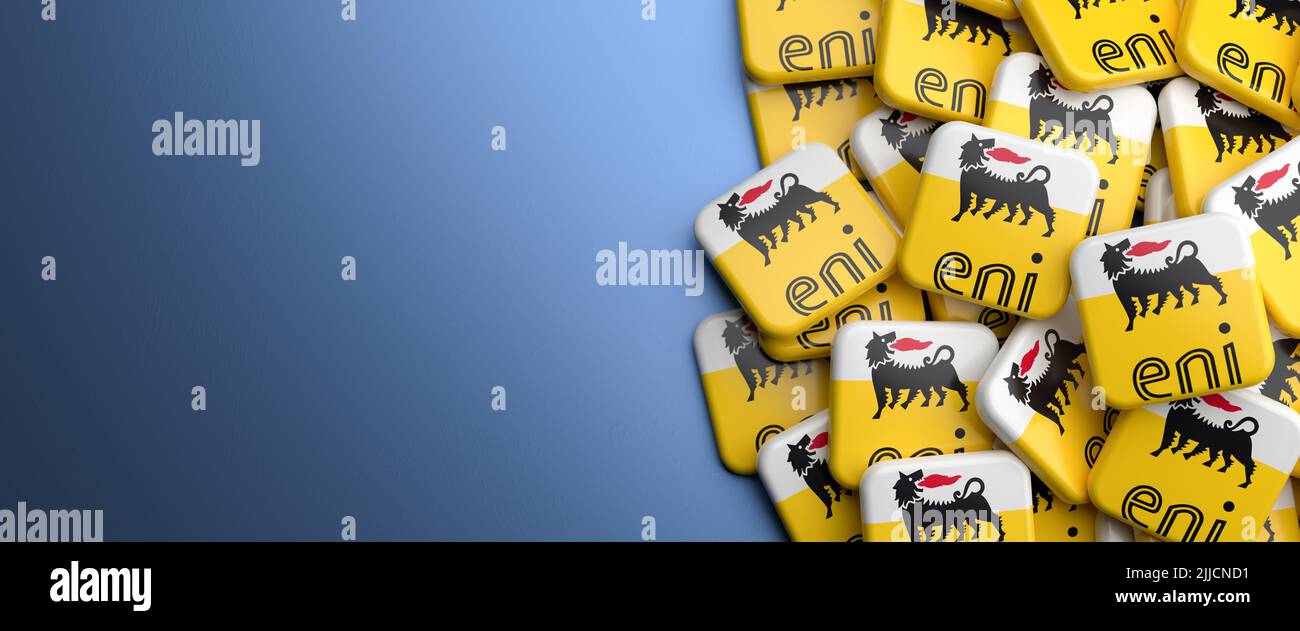 Logos of the Italian oil and gas company Eni on a heap on a table. Copy space. Web banner format. Stock Photo