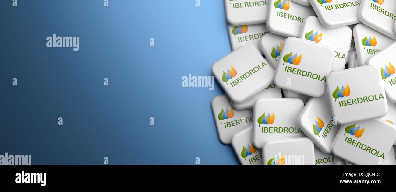 Logos of the Spanish electric utility company Iberdrola on a heap on a table. Copy space. Web banner format. Stock Photo