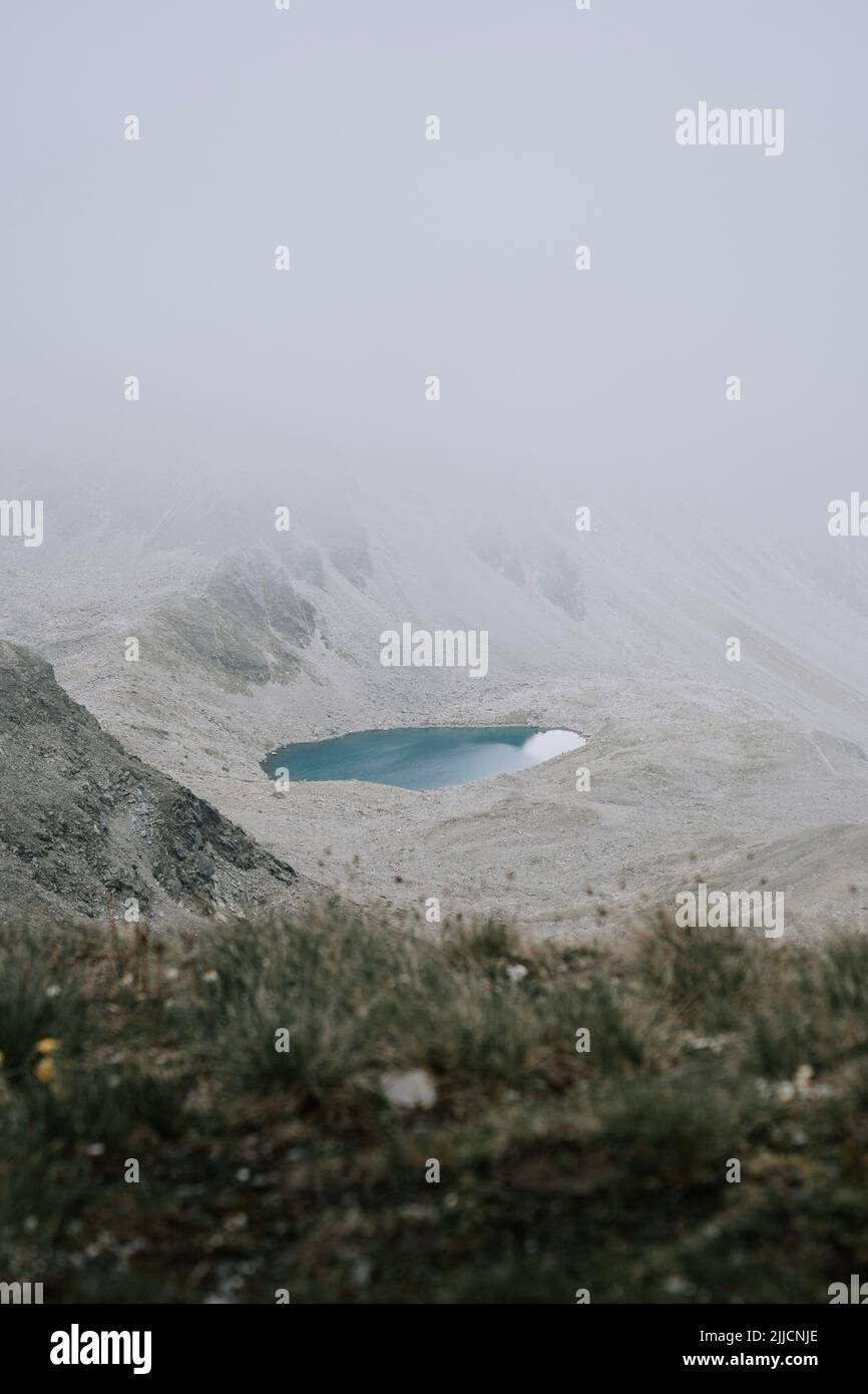 Ein blauber See in den Bergen zwischen Wolken. Schlechte Sicht und Wetter in den Bergen 2 Stock Photo