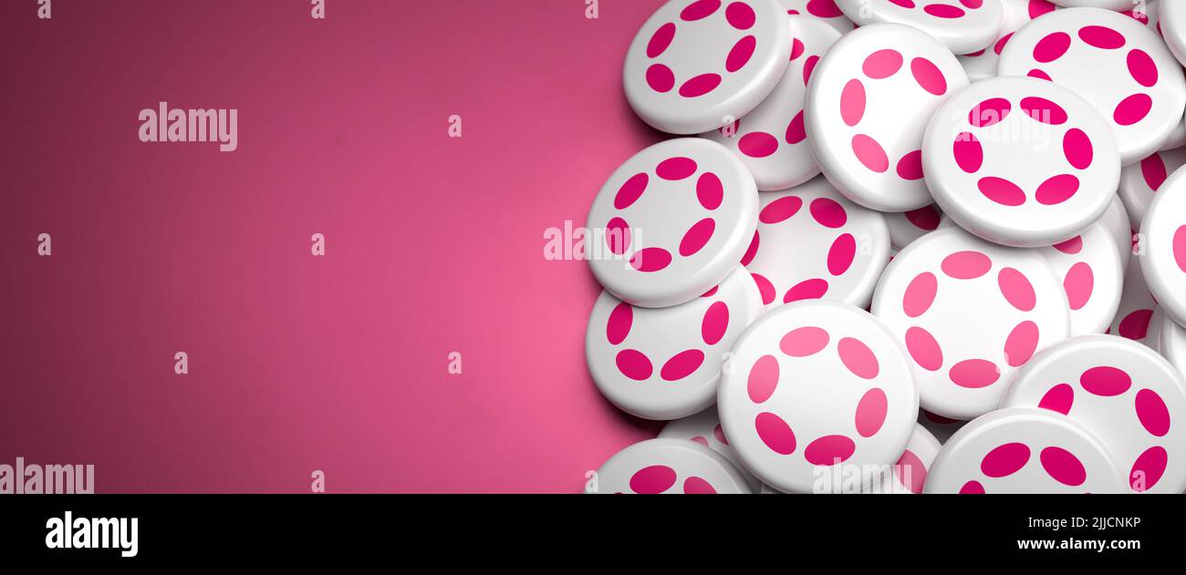 Logos of the cryptocurrency Polkadot (DOT) (version 2022) on a heap on a table. Copy space. Web banner format Stock Photo