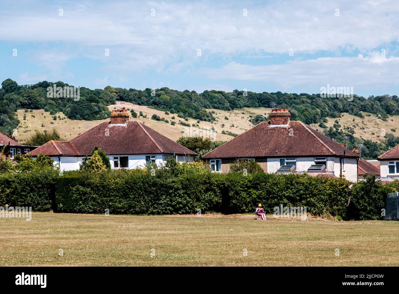 Dorking Surrey Hills London UK, July 24 2022, Woman Sitting Alone Reading A Book In A Field During Heatwave Stock Photo