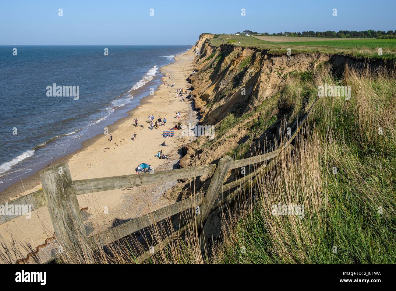 A collapsed fence caused by coastal erosion on the edge of the cliff at West Runton, Norfolk Stock Photo