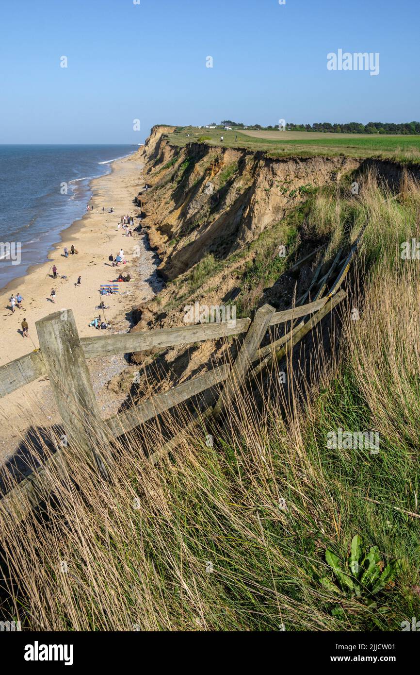 A collapsed fence caused by coastal erosion on the edge of the cliff at West Runton, Norfolk Stock Photo