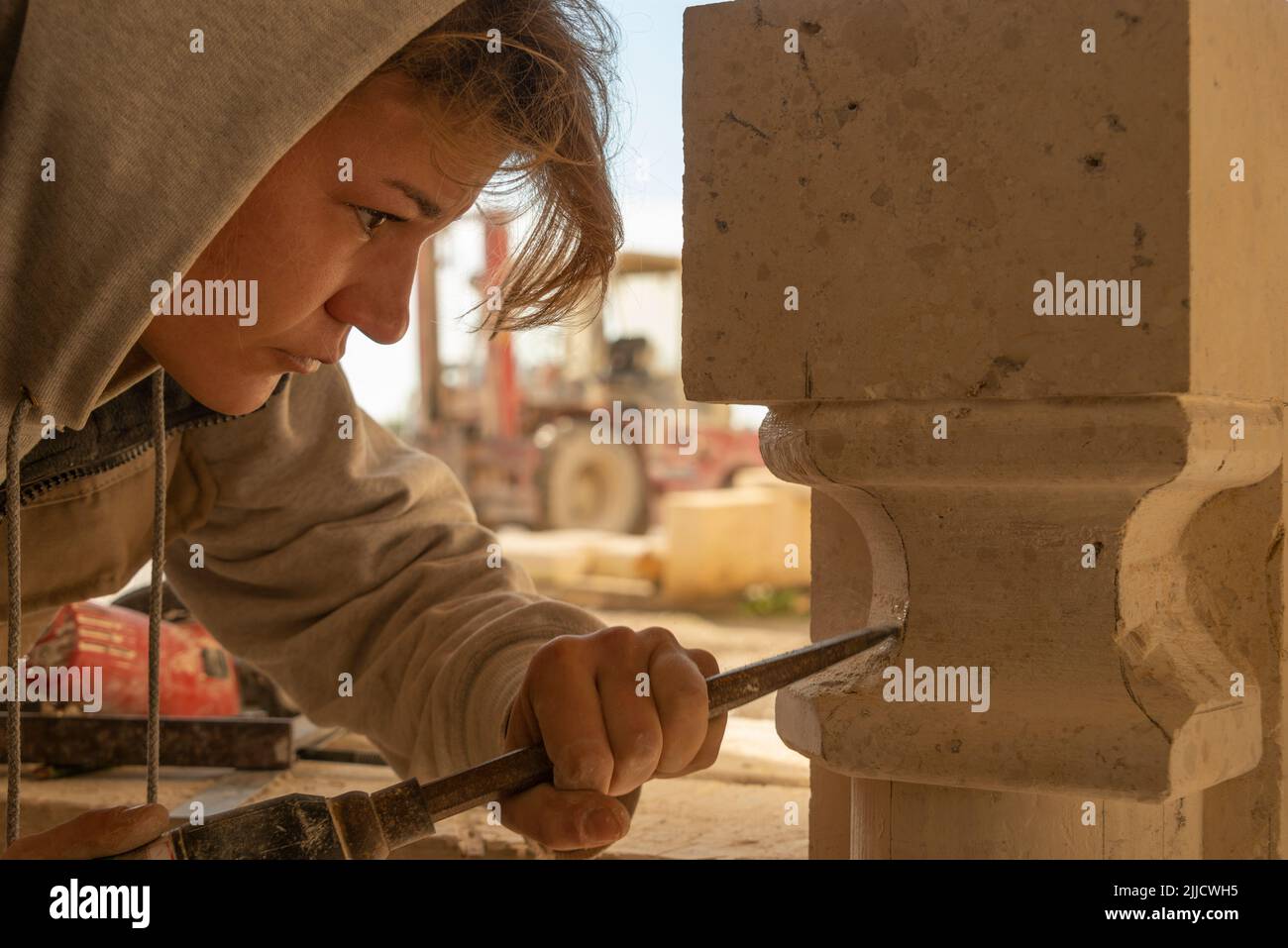 Stone mason at work cutting limestone Stock Photo