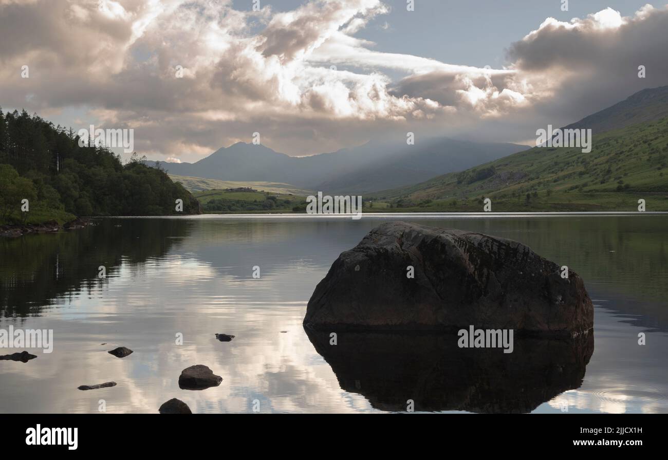Snowdonia Lake with Large Rock Stock Photo Alamy