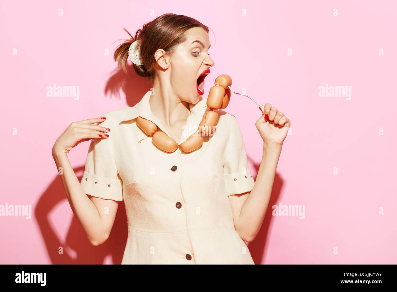 Young woman emotionally eating sausage on her necklace Creative food